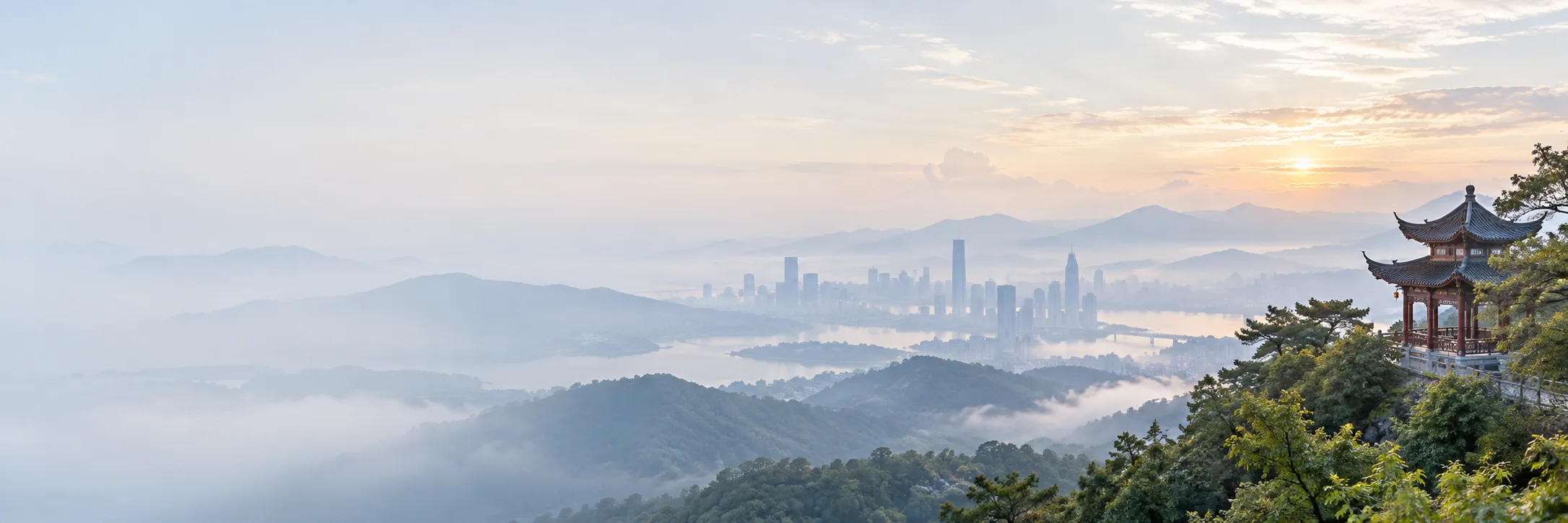 Misty sunrise over green hills, a river city skyline and a traditional Chinese pavilion